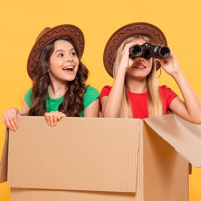 girls on adventure in cardboard box with binoculars 1